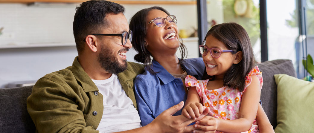 A young family sitting together on a couch