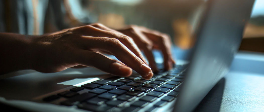 Close-up of hands typing on a keyboard