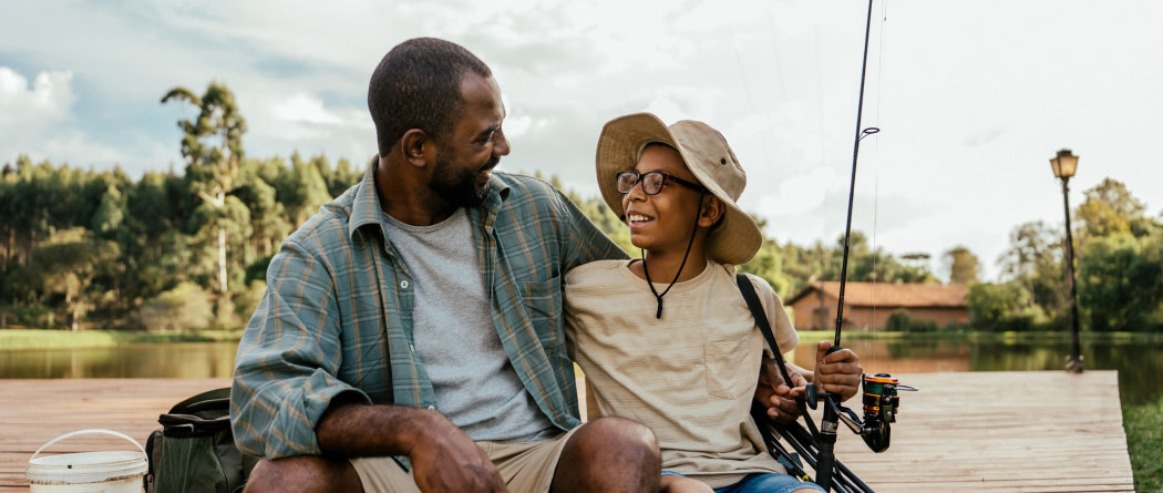 A dad and kid fishing on a dock